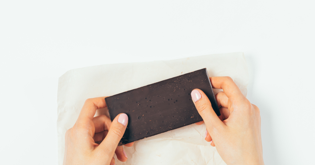 Female Hands Holding a Bar of Chocolate