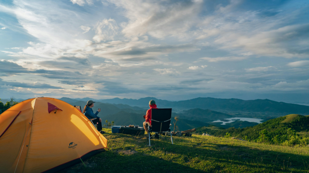 people camping enjoying the sunrise in the mountain